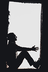 Image showing Man's silhouette in the window above blue cloudy sky