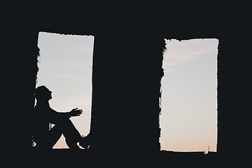 Image showing Man's silhouette in the window above blue cloudy sky