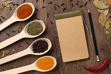 Image showing peppers, spices in spoons, notebook and pencil