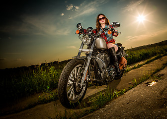 Image showing Biker girl sitting on motorcycle