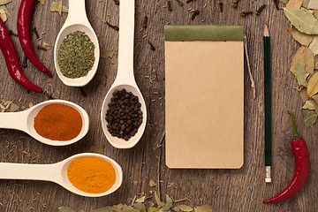 Image showing peppers, spices in spoons, notebook and pencil