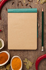 Image showing peppers, spices in spoons, notebook and pencil