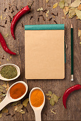 Image showing peppers, spices in spoons, notebook and pencil