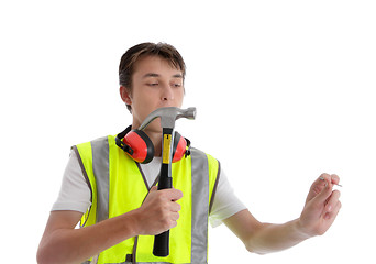 Image showing Teen apprentice with hammer and nail