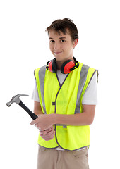 Image showing Young teen apprentice builder holding hammer