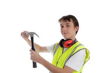 Image showing Teenager using a hammer and nail