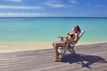 Image showing Beautiful young woman with a drink by the sea