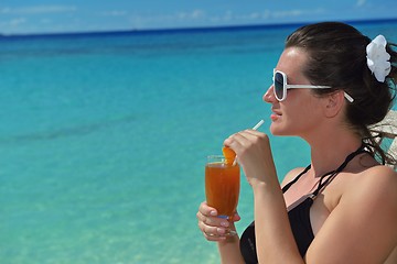 Image showing Beautiful young woman with a drink by the sea