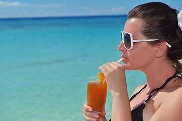 Image showing Beautiful young woman with a drink by the sea