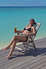 Image showing Beautiful young woman with a drink by the sea