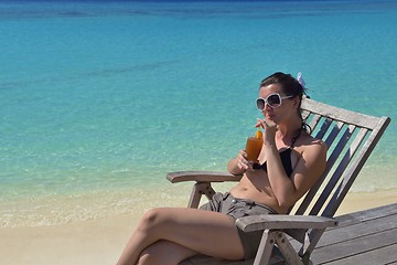 Image showing Beautiful young woman with a drink by the sea