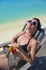 Image showing Beautiful young woman with a drink by the sea