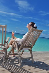 Image showing Beautiful young woman with a drink by the sea