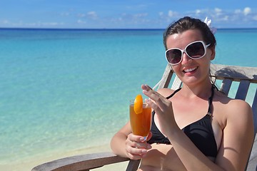 Image showing Beautiful young woman with a drink by the sea