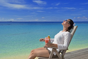 Image showing Beautiful young woman with a drink by the sea