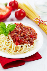 Image showing Portion of spaghetti bolognese with green basil leaf on white pl