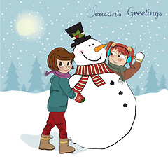 Image showing two happy girls building a snowman