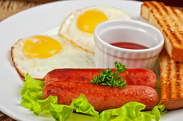 Image showing Fried eggs with sausages