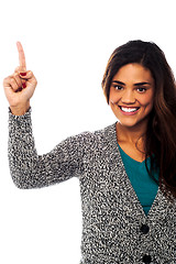 Image showing Smiling woman pointing upwards