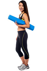 Image showing Full length portrait of slim girl holding blue mat