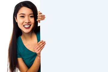 Image showing Asian girl holding blank white ad board