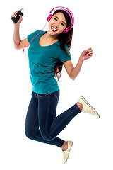 Image showing Music lover jumping high in the air