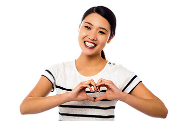 Image showing Pretty woman making heart symbol with hands