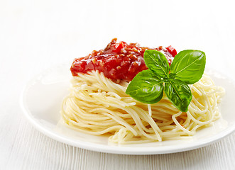 Image showing Spaghetti bolognese and green basil leaf on white plate