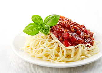 Image showing Spaghetti bolognese and green basil leaf on white plate