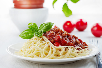 Image showing Spaghetti bolognese and green basil leaf on white plate