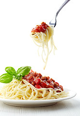 Image showing Spaghetti bolognese and green basil leaf on white plate