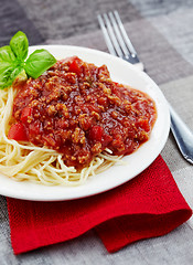 Image showing Spaghetti bolognese and green basil leaf on white plate