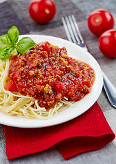 Image showing Spaghetti bolognese and green basil leaf on white plate