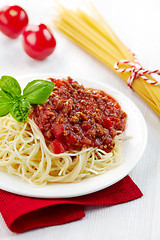 Image showing Spaghetti bolognese and green basil leaf on white plate