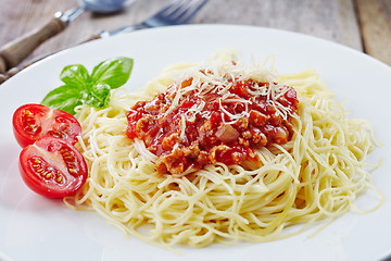 Image showing Spaghetti bolognese and green basil leaf on white plate