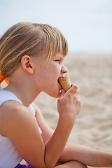 Image showing Young girl eating ice cream on beach