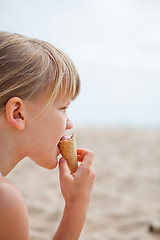 Image showing Young girl eating ice cream on beach