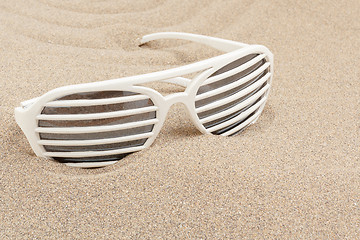 Image showing funny sun glasses in sand