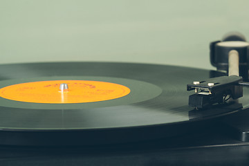 Image showing Spinning vinyl record. Motion blur image.  Vintage toned. 