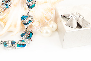 Image showing two pearl earrings and sea shells on white