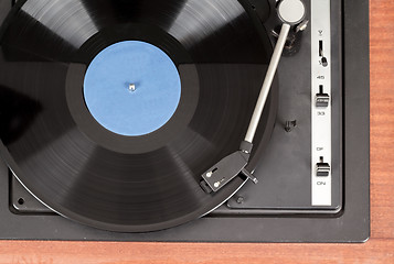 Image showing Spinning vinyl record. Motion blur image.  Vintage toned. 