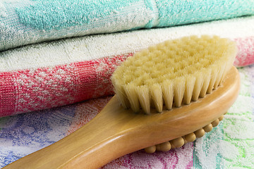 Image showing Wooden brush with the handle for massage of a body and a towel. 
