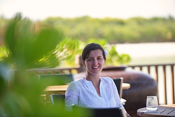 Image showing Beautiful young woman with a drink by the sea