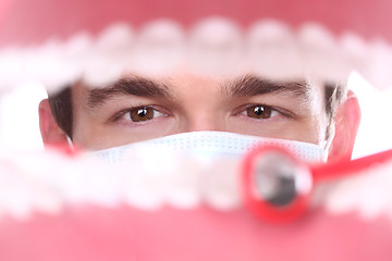 Image showing Caucasian Dentist Working Inside a Patient Mouth