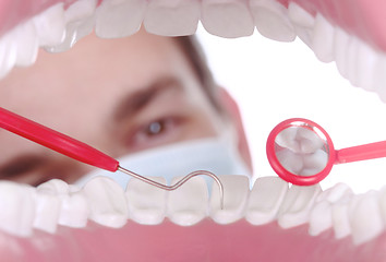 Image showing Caucasian Dentist Working Inside a Patient Mouth