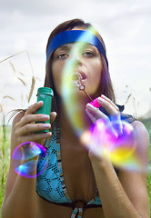 Image showing woman blowing soap bubble