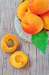 Image showing fruits apricot in basket on wooden background