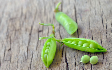 Image showing Fresh green peas on an old wooden background