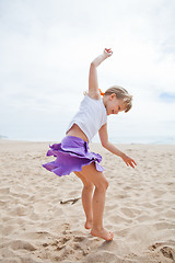 Image showing Young girl jumping in sand