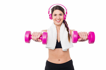 Image showing Woman enjoying music while doing dumbbells